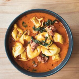 Warm and hearty tortellini soup with savory sausage and spinach in a flavorful broth.