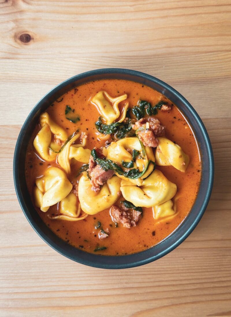 Warm and hearty tortellini soup with savory sausage and spinach in a flavorful broth.