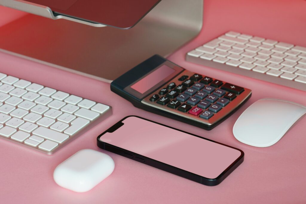 Pink desk with pink phone and calculator