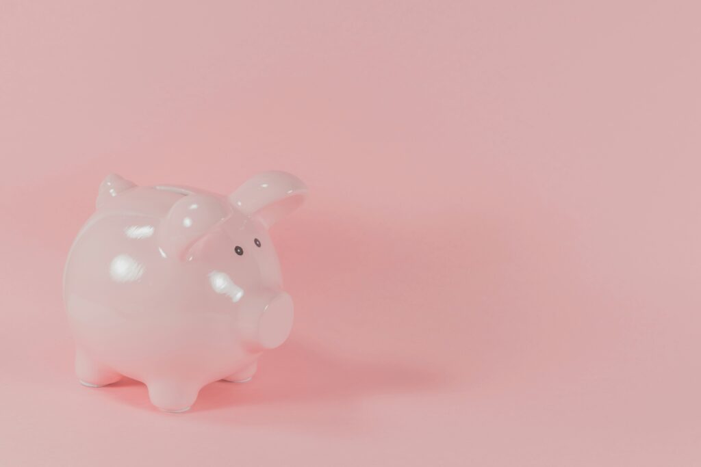 Pink piggy bank against a pink background 