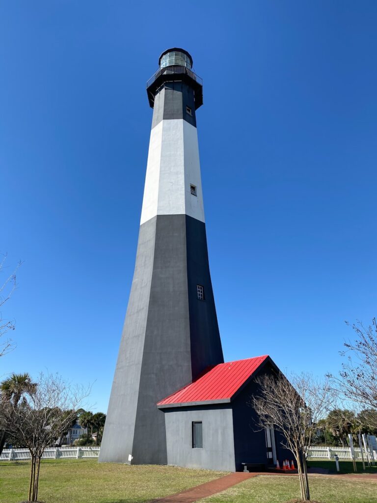 white and black concrete lighthouse under blue sky during daytime